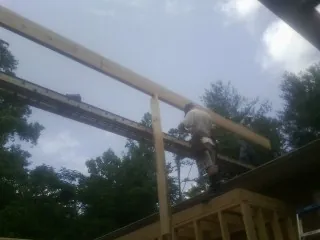 Carpenter setting a ridge beam over a new addition frame — Ice Dam Removal by Roofing Brothers in Maryville